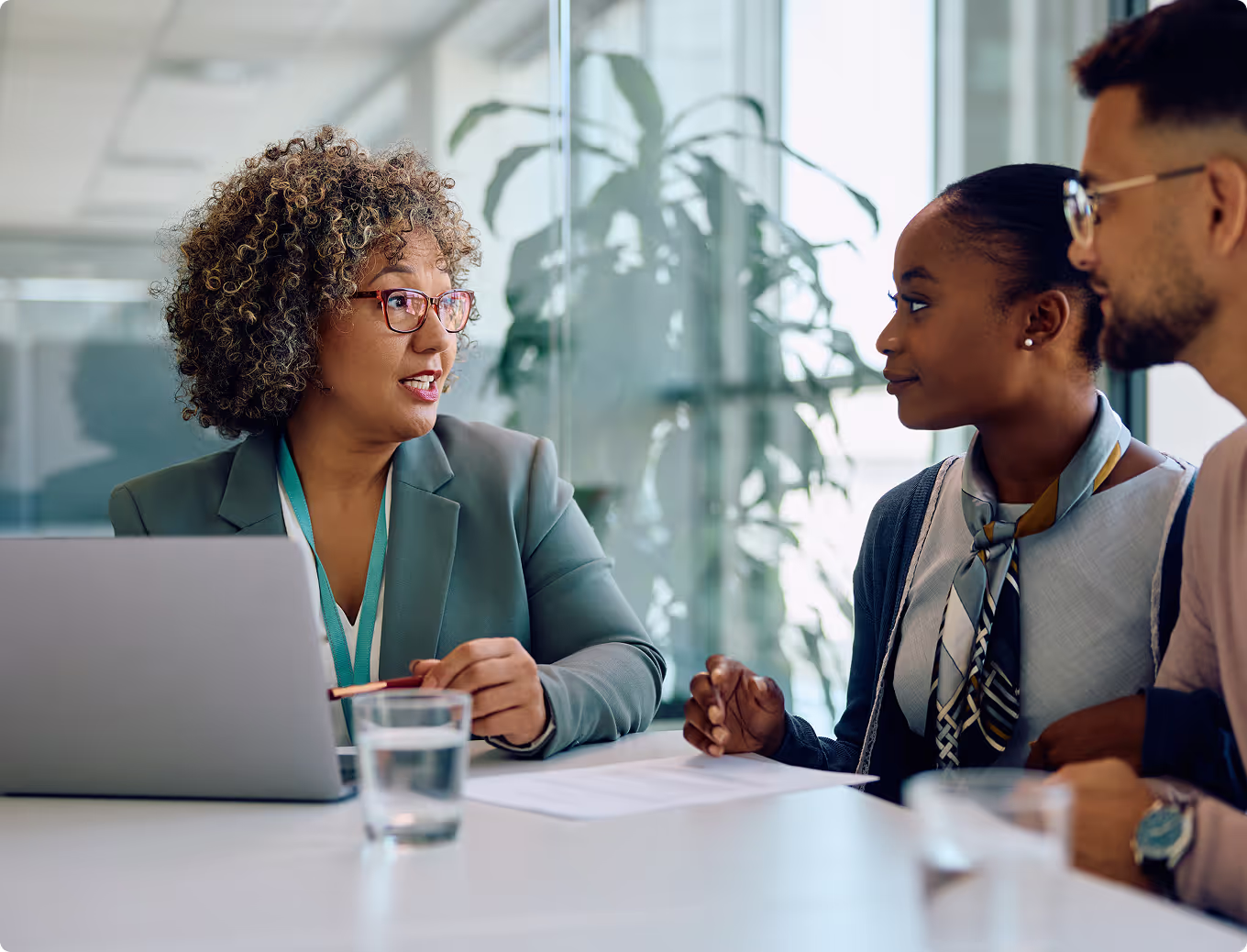 A woman in a suit is talking to two other women.