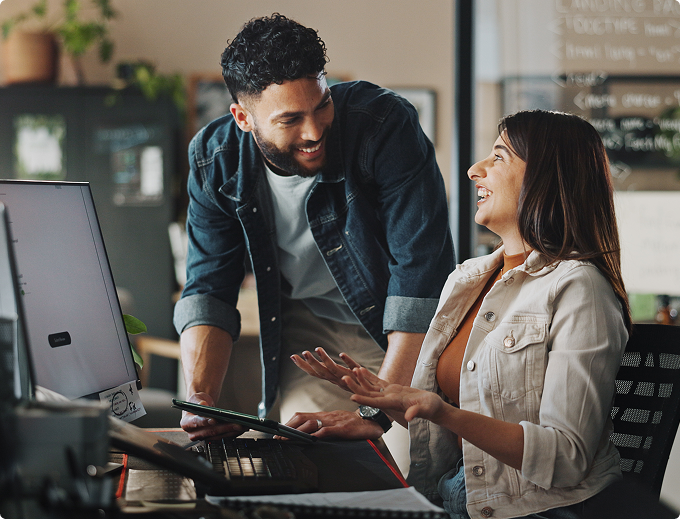 Two colleagues reviewing loan application data together.