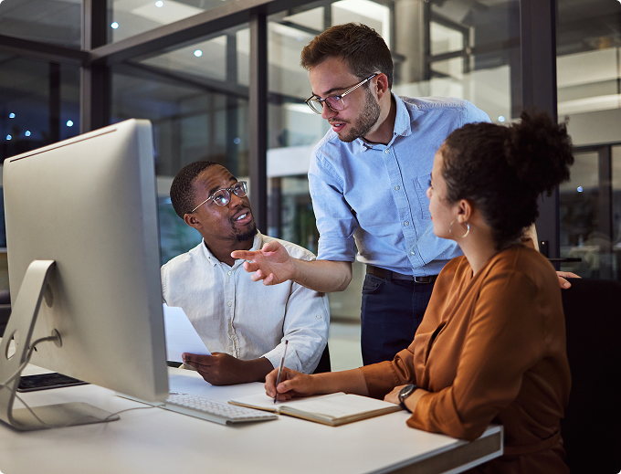 A man and woman are standing in a kitchen, smiling and holding a piece of paper.